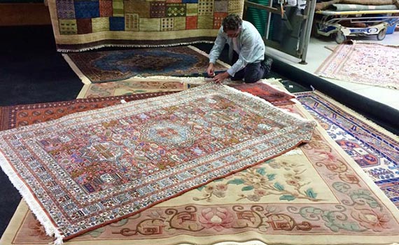 man inspecting rug